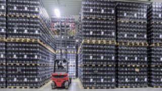 Le chariot électrique X35 Linde empile des caisses de boissons dans un entrepôt d’Ensinger
